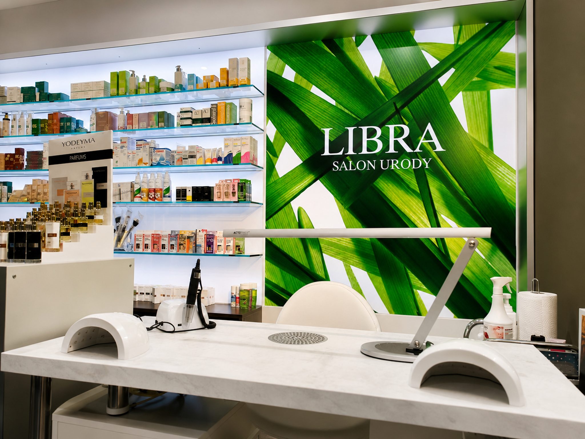 Stanowisko manicure przy podświetlonej ścianie z logo Libra